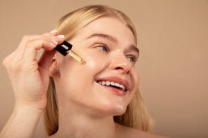 O femeie aplicând retinol pe un ten curat și sănătos